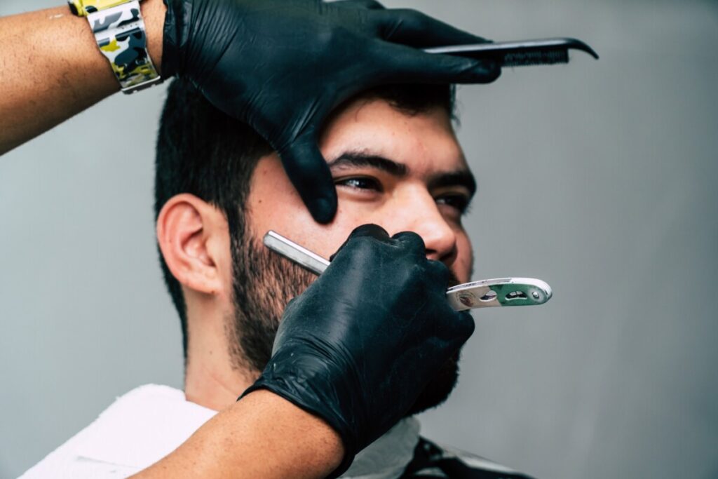 A man carefully shaving his beard, showcasing the art of traditional grooming.